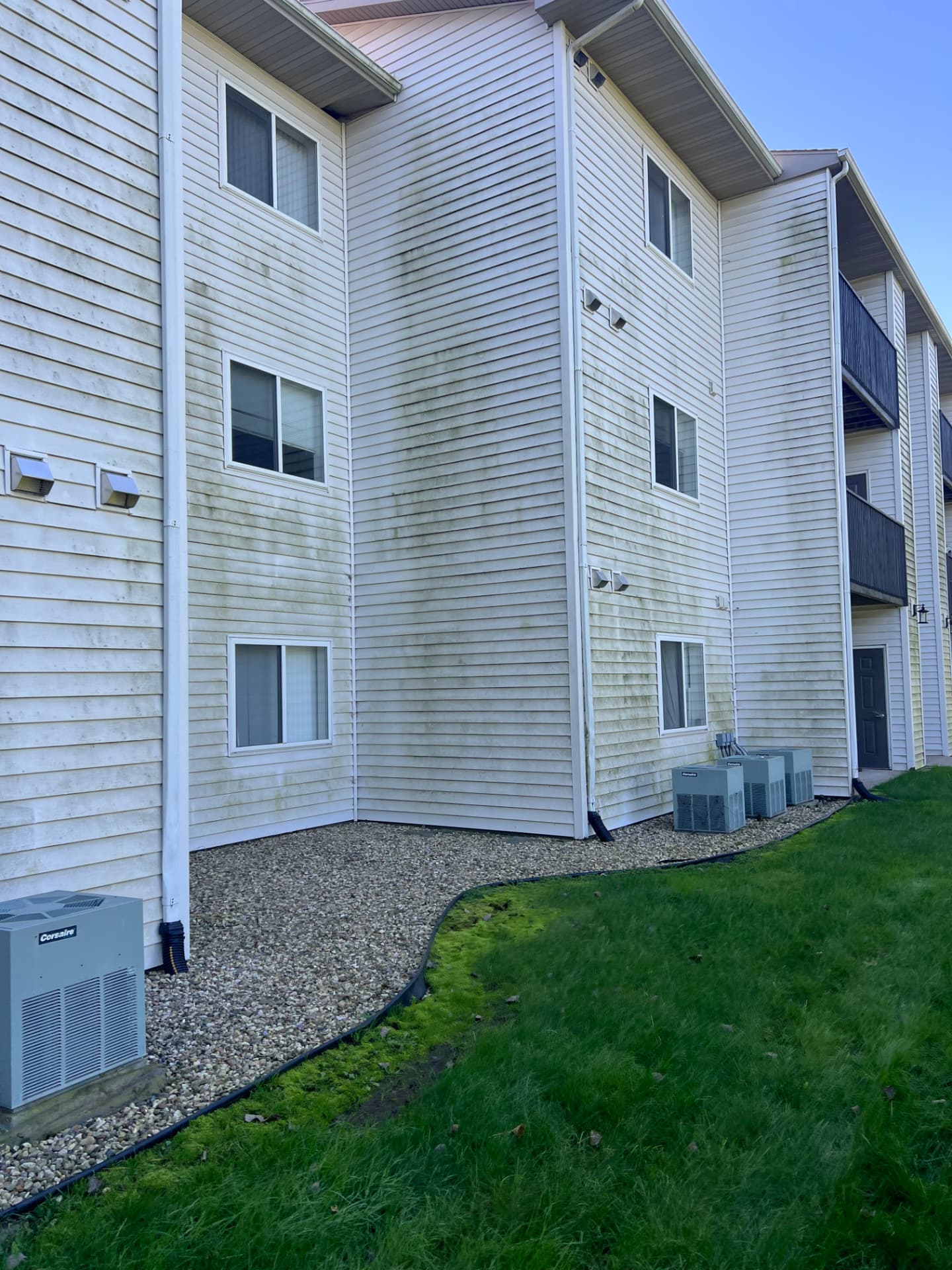 Apartment siding showing green discoloration before cleaning